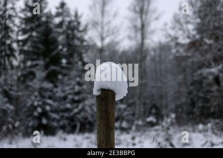 Weiße Schneekappen an den Zaunpfosten. Stockfoto