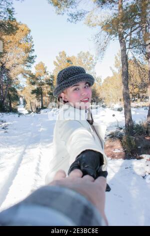 Nahaufnahme Foto kaukasische Frau mit romantischen Lächeln lachen, während posiert auf Schnee Hintergrund mit den Händen hielt ihren Freund. Winter Im Freien 2021. Stockfoto