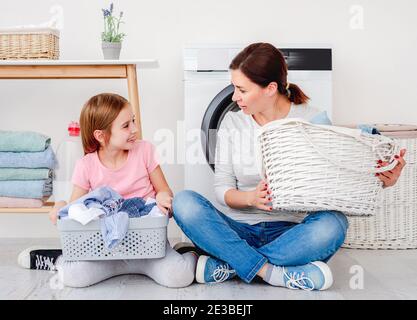 Kleines Mädchen hilft Mutter während des Waschens Stockfoto