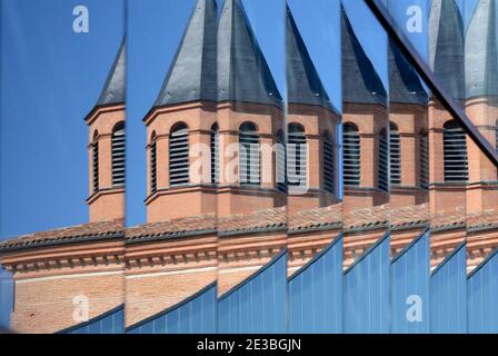 Abstraktes verzerrtes Bild des Naturhistorischen Museums mit Ziegelstein Turm reflektiert in Spiegelglas Moderne Exteension Toulouse Frankreich Stockfoto