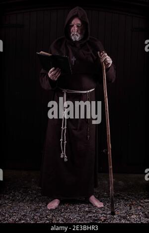 Franziskanermönch, barfuß, mit seiner bibel und seinem Stab. Stockfoto