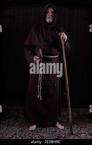 Franziskanermönch, barfuß, mit seiner bibel und seinem Stab. Stockfoto