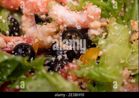 Gemüsesalat mit Garnelen und Pinienkernen auf einem Teller. Hausgemachtes Essen. Nahaufnahme Stockfoto