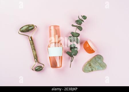 Plastikflaschen und Gläser auf rosa Hintergrund Stockfoto