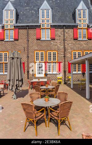 Leere Tische und Stühle vor einem geschlossenen Restaurant in Tubbergen, Niederlande Stockfoto