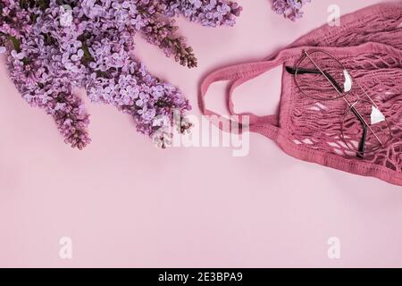 Frühlingskomposition mit lila Fliederblüten, Saitenbeutel und Gläsern. Stockfoto