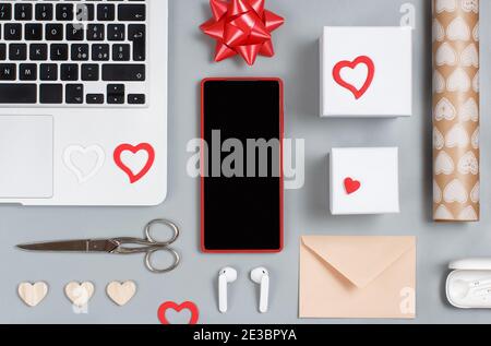 Geschenkverpackung Valentinstag Geschenk auf dem grauen Tisch mit Gadgets Draufsicht Stockfoto