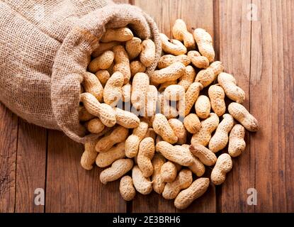 Erdnüsse im Sack auf Holztisch, Draufsicht Stockfoto