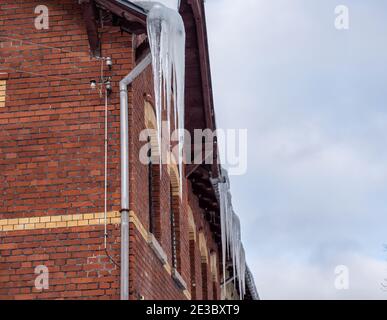 Eiszapfen hängen auf dem Dach - tödliche Gefahr Stockfoto