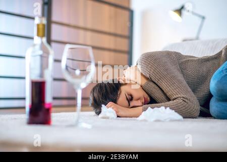 Junge Frau fühlt sich deprimiert und trinkt Alkohol Stockfoto