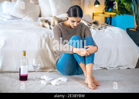 Junge Frau fühlt sich deprimiert und trinkt Alkohol Stockfoto