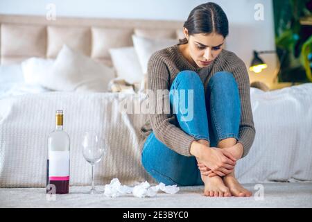 Junge Frau fühlt sich deprimiert und trinkt Alkohol Stockfoto