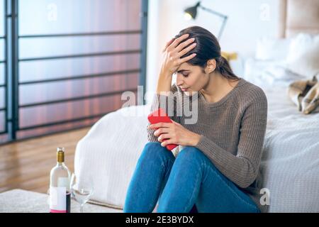 Junge Frau fühlt sich gestresst und trinkt Alkohol Stockfoto