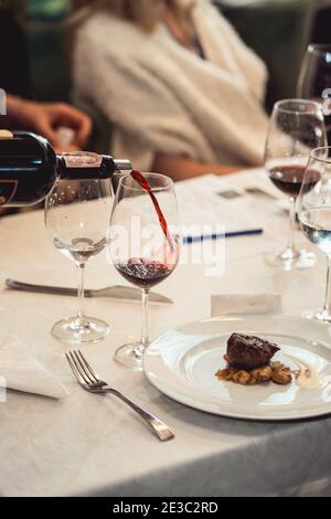 Sommelier Gießen Wein in Glas bei der Weinprobe. Verschiedene Weingläser auf dem Tisch bei der Weinprobe. Sommelier spricht darüber, wie verschiedene Formen von g Stockfoto