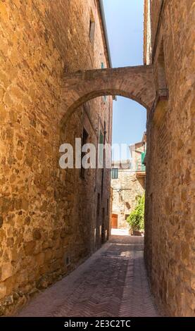 Ein steinerner Torbogen über eine Straße im Dorf Pienza in der Provinz Siena, Toskana, Italien Stockfoto