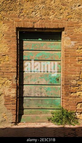 Eine alte Tür in einem historischen Steinwohngebäude im Dorf Pienza in der Provinz Siena, Toskana, Italien Stockfoto