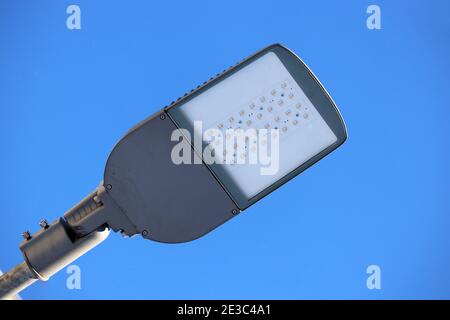 LED-Lampe auf blauem Himmel Hintergrund. Elektrische Beleuchtung, energiesparende Straßenlaterne Stockfoto