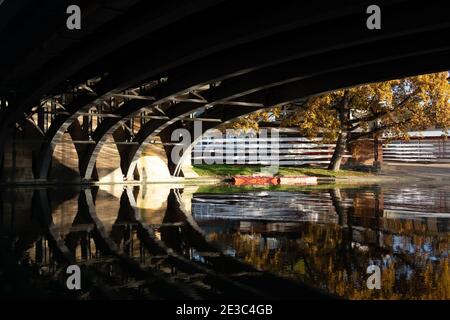 Unter Victoria Brücke mit Spiegelungen auf dem Fluss und Rudern Boote auf dem Flussufer im Hintergrund River Cam Cambridge, England Stockfoto