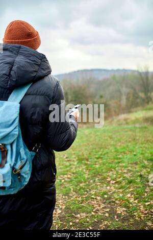 Reisender Mann mit Rucksack mit Kompass in der Hand auf dem Hintergrund der Berge Fluss der Natur, Reisekonzept, Campingausflug, GPS, Orientierungslauf, Navigat Stockfoto