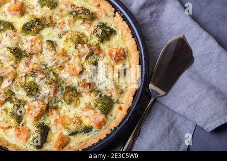 Quiche (offener Kuchen) mit Forelle, Brokkoli und Käse. Hausgemachte ungesüßte Backwaren, traditionelle Kuchen. Nahaufnahme. Stockfoto