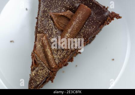 Digestive Biscuit Basis mit Schokolade Käsekuchen und Taschen von gesalzener Karamell-Sauce, gekrönt mit Schokolade Ganache, Milchschokolade Locken und Gold sh Stockfoto