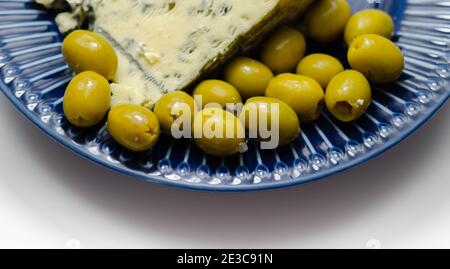 Eingelegte Oliven gefüllten Knoblauch mit vollem Fett weichen blau geäderten Käse auf der blauen Platte, leckere Vorspeise Stockfoto