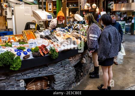 Junge asiatische Frauen kaufen Meeresfrüchte im Borough Market, London, Großbritannien. Stockfoto