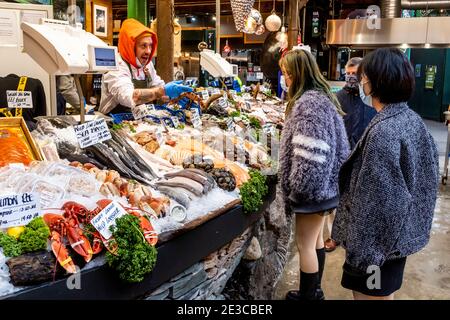 Junge asiatische Frauen kaufen Meeresfrüchte im Borough Market, London, Großbritannien. Stockfoto