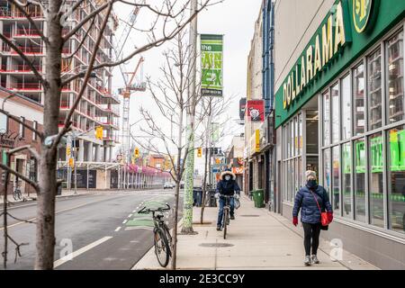 Toronto, Ontario, Kanada. Januar 2021. Menschen, die Masken als vorbeugende Maßnahmen tragen, gehen während der COVID-19 Pandemie auf einer verlassenen Straße in der Innenstadt. Quelle: Shawn Goldberg/SOPA Images/ZUMA Wire/Alamy Live News Stockfoto