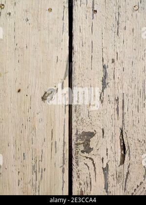 Alte Holzbretter mit grauer abblätternder Farbe mit Rissen. Raue Oberflächenstruktur. Stockfoto