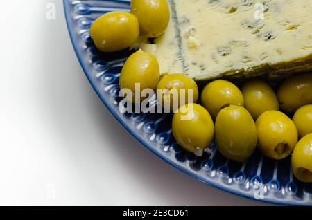 Eingelegte Oliven gefüllten Knoblauch mit vollem Fett weichen blau geäderten Käse auf der blauen Platte, leckere Vorspeise Stockfoto