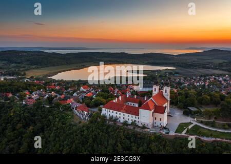 Tihany, Ungarn - Luftpanorama des berühmten Benediktinerklosters von Tihany (Tihany Abtei, Tihanyi Apatsag) mit schönem goldenen Himmel bei Sonne Stockfoto