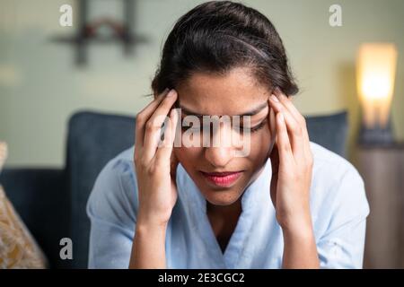 Kopfschuss von jungen Geschäftsmädchen leiden unter Kopfschmerzen - Konzept von Stress, Arbeitsdruck und Beziehungsprobleme Stockfoto