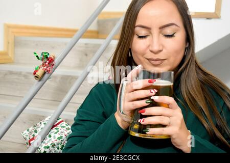 Frau drinnen, mit einem Glas Bier Stockfoto