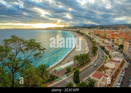 Blick auf Nizza ( Promenade des Anglais ) von Colline du Chateau . Menschen zu Fuß - Sonnenuntergang im september an der französischen Riviera . Wunderbare Palmen al Stockfoto