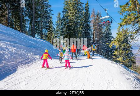 Brasov, Rumänien - 26. Februar 2018: Jugendliche und Kinder auf der Skipiste feiern Wintersport-Urlaub in Poiana Brasov Stockfoto