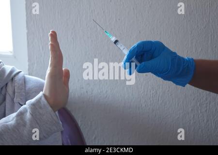 Junge Frau weigert sich, geimpft zu werden. Konzept der Unsicherheit und Angst. Es gab einen Mangel an Vertrauen in die Menschen gegen Impfstoffe. Stockfoto