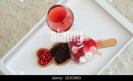 Frühstück für meine Freundin. Valentinstag Morgen. Wein und Süßigkeiten auf einem weißen Tablett. Frühstück im Bett. Stockfoto