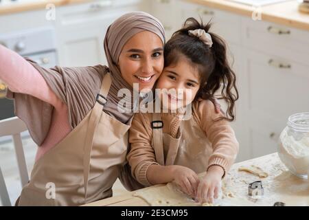 Fröhliche Muslimische Frau Nimmt Selfie Mit Ihrer Kleinen Tochter In Küche Stockfoto