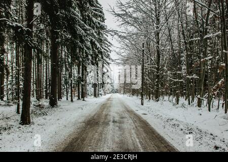 Gefährliche Strecke der Straße mit Schnee und Eis bedeckt.Snowy Straße Durch Wald.Winterpanorama.Fahren in eisiger gefrorener Landschaft.Schlechtes Wetter.S Stockfoto