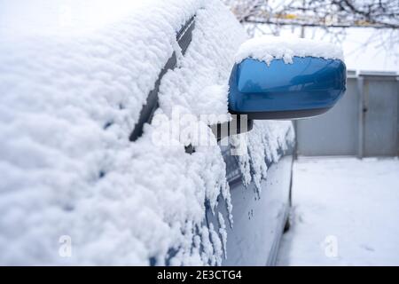 Viel Schnee auf einem blauen Auto aus nächster Nähe Stockfoto
