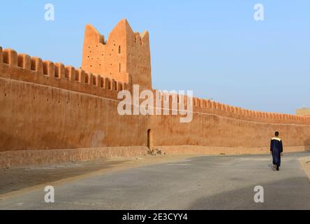 Mann, der entlang der alten Stadtmauern von Tiznit, Marokko, geht. Stockfoto