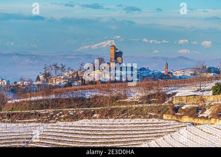 Italien Piemont: Weingärten einzigartige Landschaft Winter Sonnenuntergang, Serralunga d'Alba mittelalterlichen Dorf Burg auf einem Hügel, die Alpen schneebedeckten Berge backg Stockfoto