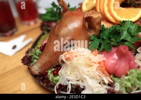 Kopf von gebratenem Schwein mit Gemüse auf einem Teller Stockfoto