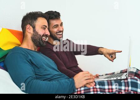 Glücklich Gay Männer paar mit Laptop im Bett - homosexuell Liebe und Gleichstellung der Geschlechter im Beziehungskonzept Stockfoto