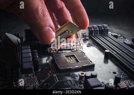 Techniker schließen den CPU-Mikroprozessor an den Sockel der Hauptplatine an. Hintergrund des Workshops. PC-Upgrade- oder Reparaturkonzept. Stockfoto