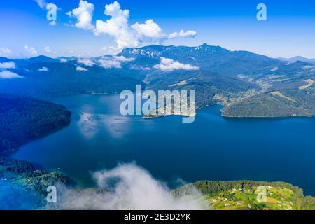 Luftlandschaft von Sommersee und grünen Berg in rumänischen Karpaten, Ceahlau Massiv, niedrige Wolken Szene Stockfoto