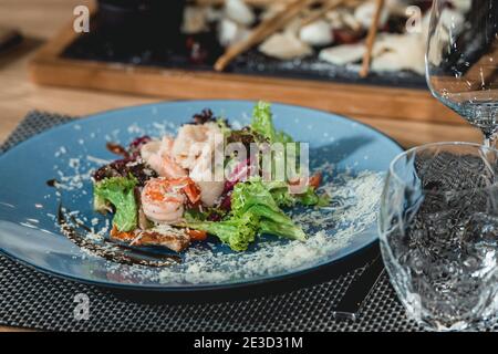 Köstlicher Lachssalat mit Garnelen und Ei im Restaurant. Kleine Portion Stockfoto