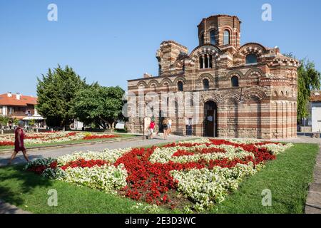 Kirche Christi Pantokrator mit Besuchern vor und weißen und roten Blumen in einem Blumenbeet, Nessebar Altstadt, Bulgarien Stockfoto