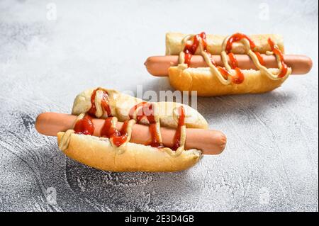Hot Dog mit gelbem Senf und rotem Ketchup. Weißer Hintergrund. Draufsicht Stockfoto